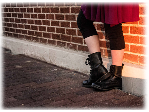 Picture of legs standing on a brick path next to a brick wall